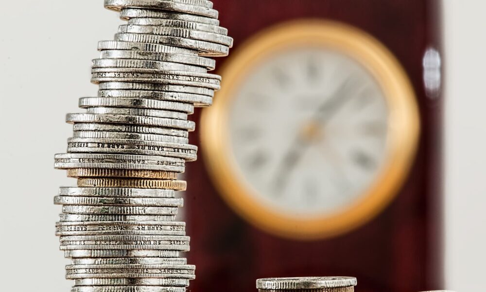 Pensions and Divorce Lawyer in Mississauga, Ontario portrayed by stack of coins near a clock.